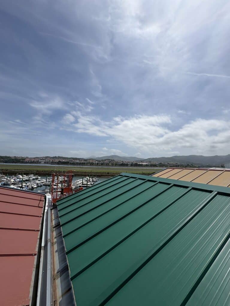 Cubierta de chapa de un pabellón en Hondarribia, con la marina de Txingudi al fondo