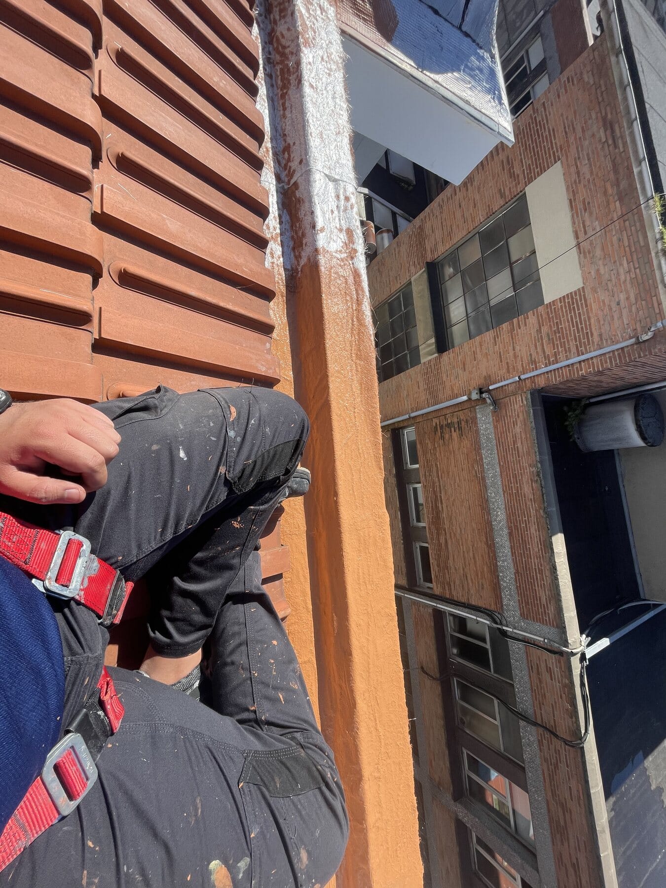 Operario en trabajos verticales sobre una fachada de ladrillo en Bizkaia